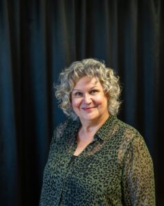 Glad kvinna med lockigt hår. Foto.