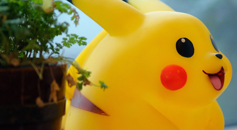 Bild på en pikachu och en grön växt som skymtar