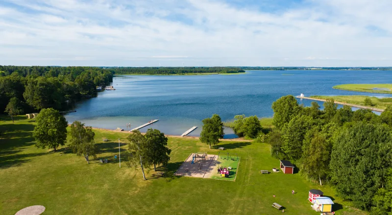 Bild tagen från drönare över badplats med stor gräsmata vid sjön Boren. Foto.