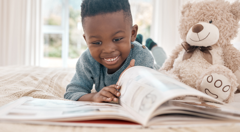 En liten pojke som tittar i en bok