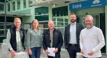 Fem personer står utanför kommunhuset. Foto.